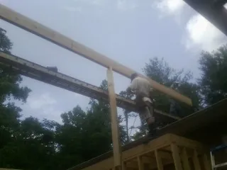 Carpenter setting a ridge beam over a new addition frame — Ice Dam Removal by Roofing Brothers in Napanoch