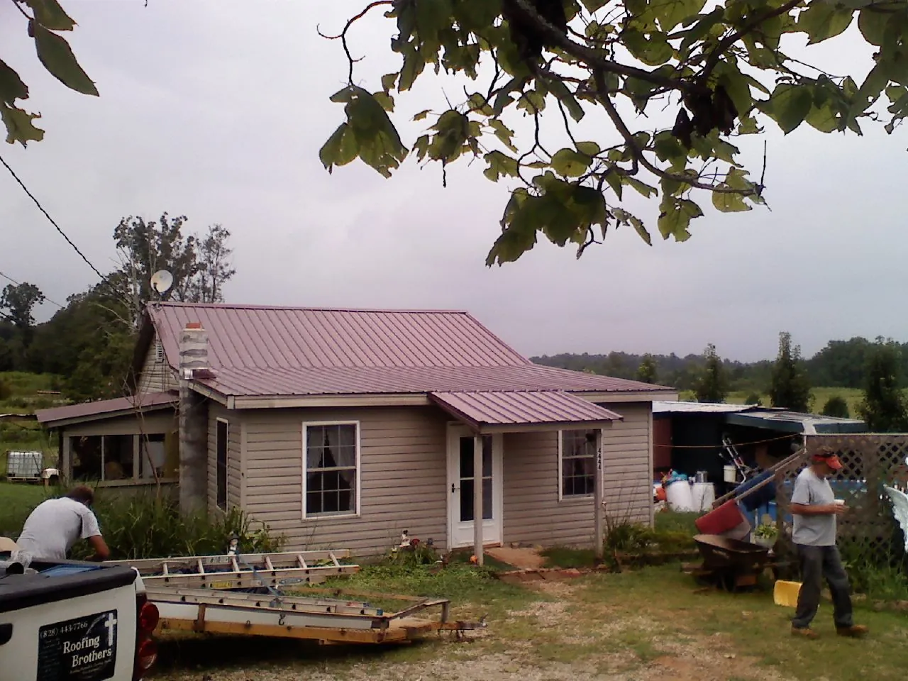 Crew finishing a mauve metal roof on a small farmhouse in Napanoch