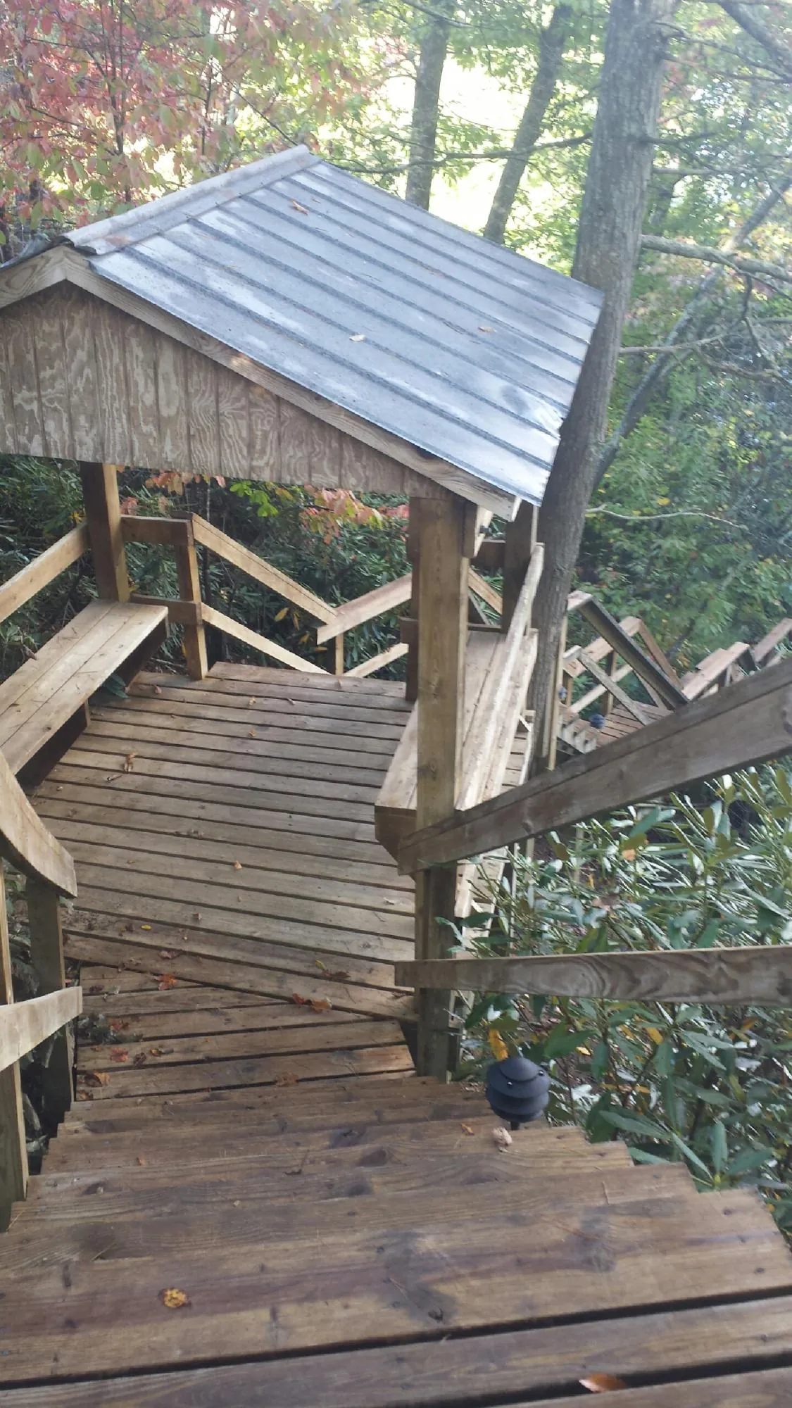 Metal roofed shelter over wooden steps on a wooded walkway — Skylight Repair & Installation work by our crew in Napanoch