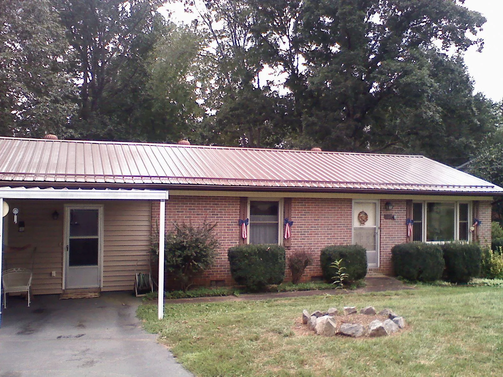 Bronze metal roof and carport on a brick ranch home — Roof Repair work by our crew in Napanoch